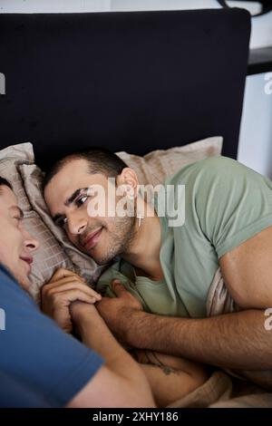 Un jeune couple gay partage un moment intime dans leur chambre, mettant en valeur leur amour et leur connexion. Banque D'Images