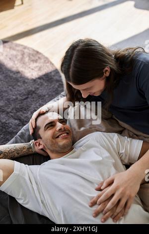 Un jeune couple gay passe un moment tranquille ensemble dans leur chambre, partageant une étreinte tendre et aimante. Banque D'Images