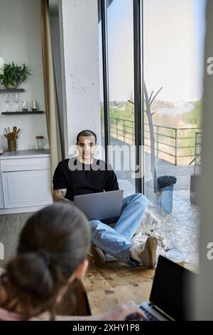 Un jeune couple gay se détend dans leur maison moderne, profitant de moments de qualité ensemble. Banque D'Images