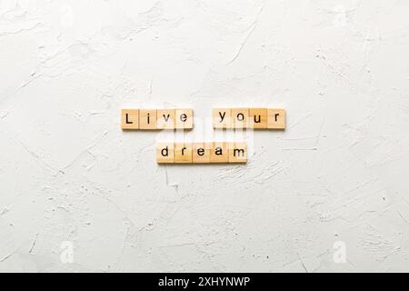 vivez votre mot de rêve écrit sur bloc de bois. vivez votre texte de rêve sur table de ciment pour votre conception. Banque D'Images