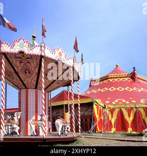 Carrousel traditionnel et tente de cirque par un matin ensoleillé à une foire en France Banque D'Images