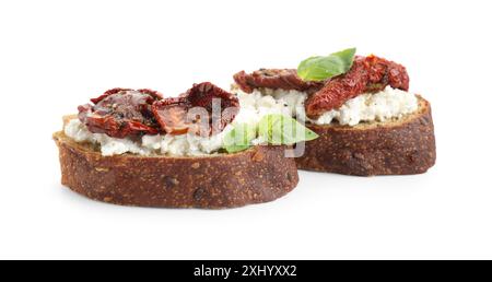 Délicieuse ricotta bruschettas avec tomates séchées au soleil et basilic isolé sur blanc Banque D'Images