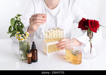 Produit d'aromathérapie. Scientifique développant des huiles essentielles à table blanche en laboratoire, gros plan Banque D'Images