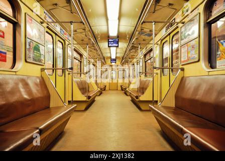 Train de métro vide. Image aux tons chauds d'un wagon vide, vue en perspective décroissante symétrique de l'intérieur du train de métro. Banque D'Images