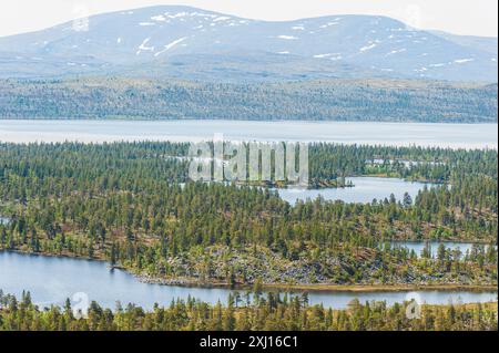 Une vue panoramique sur un paysage montagneux à Rogen, Härjedalen, Suède, avec un grand lac au loin, entouré de montagnes enneigées Banque D'Images