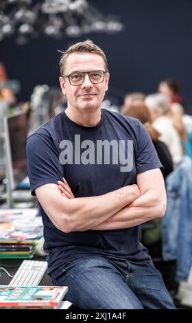 Hambourg, Allemagne. 16 juillet 2024. Stefan Heine, distributeur de casse-tête de Hambourg, est assis dans son bureau ouvert, où des casse-tête sont produits pour divers médias. Crédit : Markus Scholz/dpa/Alamy Live News Banque D'Images