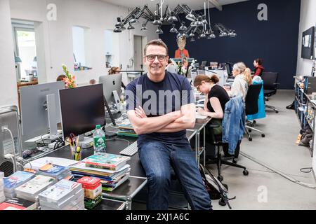 Hambourg, Allemagne. 16 juillet 2024. Stefan Heine, distributeur de casse-tête de Hambourg, est assis dans son bureau ouvert, où des casse-tête sont produits pour divers médias. Crédit : Markus Scholz/dpa/Alamy Live News Banque D'Images