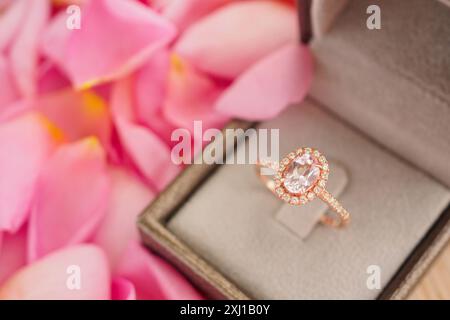 bague en diamant de mariage élégante dans la boîte à bijoux sur le beau fond rose de pétale de gros plan Banque D'Images
