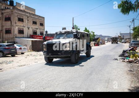 Naplouse, Palestine. 16 juillet 2024. Des véhicules militaires israéliens pénètrent dans le camp de Balata, à l'est de Naplouse, dans le nord de la Cisjordanie, au cours d'une opération visant à arrêter des Palestiniens. Les forces de l'armée israélienne ont pénétré dans une maison palestinienne après l'avoir encerclée et arrêté 3 Palestiniens recherchés par Israël. Crédit : SOPA images Limited/Alamy Live News Banque D'Images