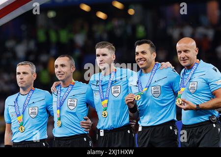 L'équipe d'arbitres guidée par François Letexier au milieu et Szymon Marciniak premier à partir de la droite vu lors de la finale de l'UEFA Euro 2024 entre natio Banque D'Images