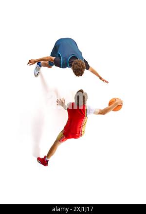 Le joueur de basket-ball de haut vol en rouge se prépare à dunk, avec le défenseur en bleu essayant de l'arrêter d'en bas sur fond blanc de studio. Antenne Banque D'Images