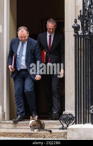 Londres, Royaume-Uni. 16 juillet 2024. Ian Murray, député (à gauche), secrétaire d'État pour l'Écosse, et Peter Kyle, député (à droite), secrétaire d'État pour la Science, l'innovation et la technologie, approchent Larry le chat alors qu'ils quittent le 10 Downing Street après une réunion du Cabinet. Le premier ministre britannique Sir Keir Starmer a indiqué que son nouveau cabinet devait « se mettre au travail » en mettant l'accent sur la réalisation des objectifs. Crédit : Mark Kerrison/Alamy Live News Banque D'Images