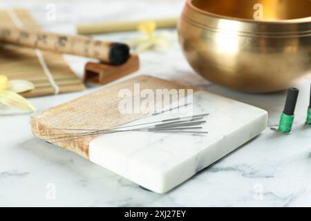 Dessous de verre avec aiguilles d'acupuncture sur table en marbre blanc Banque D'Images