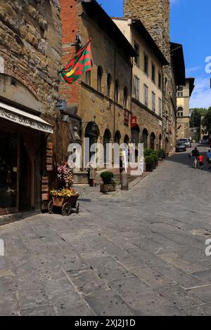 Corso Italia à Arezzo, Toscane, Italie. La rue abrite la Casa Museo Ivan Bruschi (voir au centre de cette image la bannière marron au-dessus de l'entrée du musée) et surplombe le campanile de Chiesa di Santa Maria della Pieve (la base du clocher est au-delà de l'entrée du musée). Banque D'Images