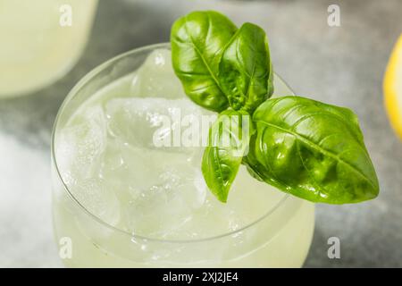 Rafraîchissant Boozy Basil Gin Smash avec citron vert Banque D'Images