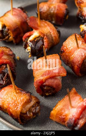 Dattes enveloppées de bacon chaud avec fromage de chèvre Banque D'Images