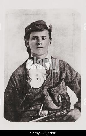 Hors-la-loi de Wild West - Jesse James, portrait en demi-longueur, face avant, tenant une arme de poing dans la main gauche à la taille - 1864 Banque D'Images