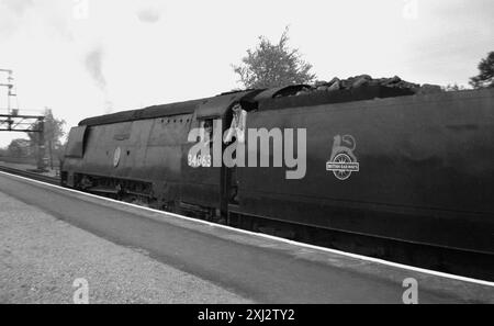 Années 1950, historique, conducteur de train et chargeur de charbon sur la locomotive à vapeur 34063, 229 Squadron stationné sur un quai ferroviaire. Connue sous le nom de locomotive de la bataille d'Angleterre, elle a été construite en 1947 à Brighton locomotive Works et a fonctionné sur la West Country Line jusqu'en 1965. Nom et logo de la British Railways sur le charriot de charbon, l'emblème Lion on Wheel conçu par Abram Games. Banque D'Images