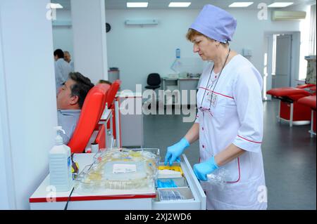 À la station de transfusion sanguine de la ville (municipale). Infirmière préparant des récipients pour transfusion sanguine, donneurs couchés dans des lits d'hôpital. 5 avril 2019. Kie Banque D'Images