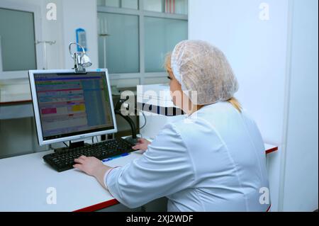 Assistant de laboratoire regardant le moniteur avec les données de tests sanguins visibles. La station de transfusion sanguine de la ville (municipale). 5 avril 2019. Kiev, Ukraine Banque D'Images