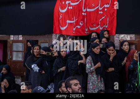 Srinagar, Inde. 16 juillet 2024. Les femmes chiites du Cachemire Raise participent à la procession dans les intérieurs du lac Dal à Srinagar le 9 de Mouharram, le premier et le plus Saint mois du calendrier islamique. Les musulmans chiites commémorent Mouharram comme un mois de deuil en souvenir du martyre du petit-fils du prophète islamique Mahomet, l'imam Hussain, qui a été tué avec les membres de sa famille à Ashura (le 10ème jour de Muharram) dans la bataille de Karbala dans le sud de l'Irak en 680 A.D. (photo de Faisal Bashir/SOPA images/Sipa USA) crédit : Sipa USA/Alamy Live News Banque D'Images