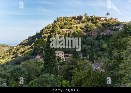 Superbe paysage urbain d'un petit village Deia à Mallorca, Espagne. Maisons traditionnelles situées en terrasses sur les collines entouré d'arbres verts Banque D'Images