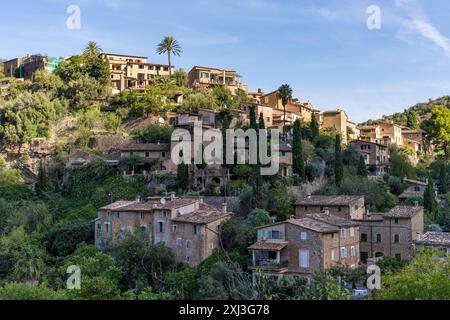 Superbe paysage urbain d'un petit village Deia à Mallorca, Espagne. Maisons traditionnelles situées en terrasses sur les collines entouré d'arbres verts Banque D'Images