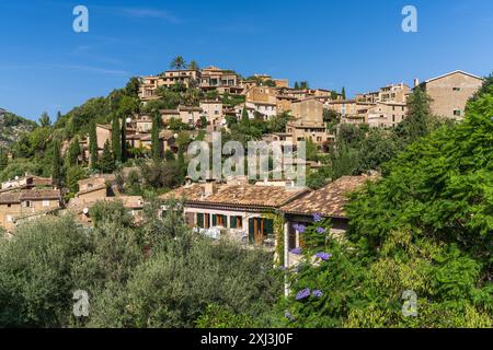 Superbe paysage urbain du petit village côtier de Deia à Majorque, Espagne. Maisons traditionnelles mitoyennes sur des collines entourées d'arbres verdoyants. Touriste de Banque D'Images