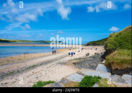 Les gens marchent sur la plage de sable sur l'estuaire de Camel lors d'une journée d'été ensoleillée Rock Cornwall Angleterre Royaume-Uni Banque D'Images