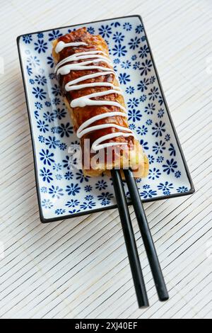 Hashimaki, une crêpe japonaise salée au chou sur une baguette Banque D'Images