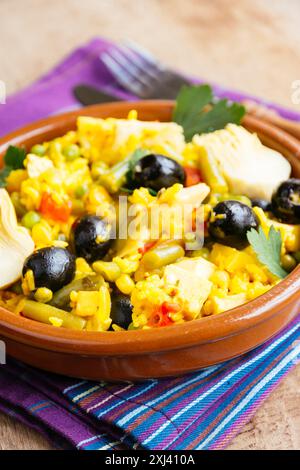 Paella végétarienne avec artichaut, olives noires, haricots verts et poivron rouge. Banque D'Images
