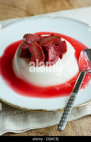 Panna cotta de fleur de sureau végétalienne faite maison avec un coulis de rhubarbe. Banque D'Images