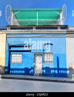 507 Maison de façade bleue, terrasse couverte en tôle de polycarbonate vert, en pente Francisco Aguilera Street East Tract après Plaza Marte Square. Santiago-Cuba. Banque D'Images