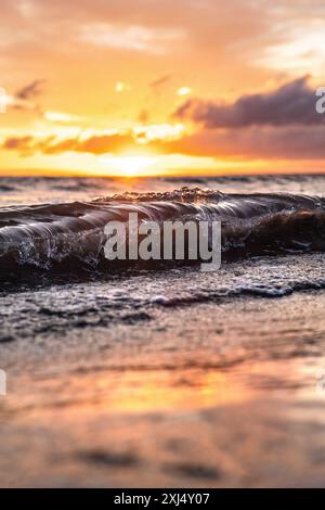 Éclaboussure dorée de vagues sur le coucher du soleil, belles couleurs du ciel et du coucher du soleil. Banque D'Images