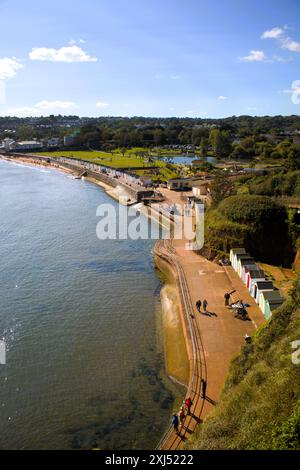 En regardant vers le bas la promenade Goodrington North Sands à marée haute avec ses cabanes de plage colorées et Sands Park avec son lac de navigation, Paignton, Torbay, Banque D'Images