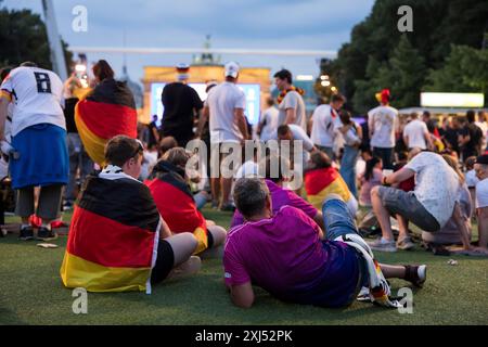 Les fans de Fassball célèbrent et rassemblent des informations dans la zone des fans au Brandenburg Tor après l'interruption de la manche du 16 match entre l'Allemagne Banque D'Images