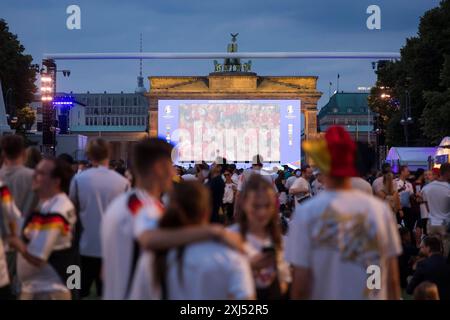 Les fans de Fassball célèbrent et rassemblent des informations dans la zone des fans au Brandenburg Tor après l'interruption de la manche du 16 match entre l'Allemagne Banque D'Images