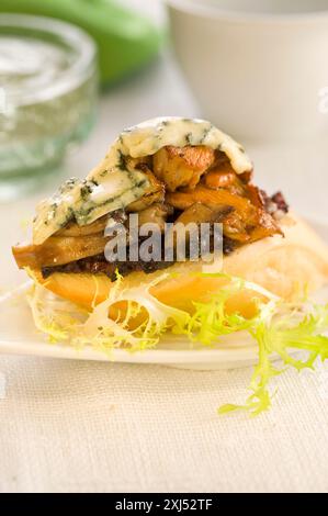 Saucisse de sang, champignons et roquefort sur une tranche de pain de la taille d'une bouchée Banque D'Images