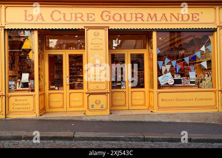 Paris, France, Europe, vitrine accueillante de la Cure gourmande en jaune chaud, tentante avec chocolat et pâtisseries Banque D'Images