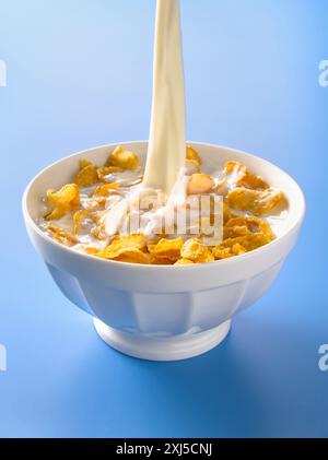 Verser le lait dans un bol de cornflakes Banque D'Images