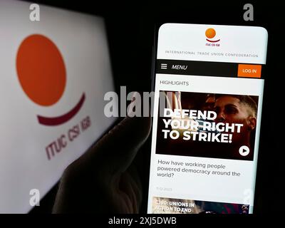 Stuttgart, Allemagne, 02-13-2024 : personne tenant un smartphone avec la page web de la Fédération Confédération syndicale internationale (CSI) avec le logo. Mise au point Banque D'Images