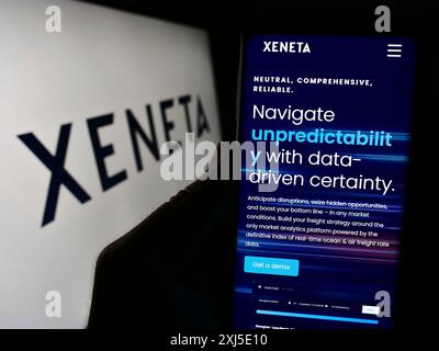Stuttgart, Allemagne, 02-13-2024 : personne tenant un smartphone avec le site Web de la société norvégienne d'analyse des expéditions Xeneta COMME devant le logo. Concentrez-vous sur Banque D'Images