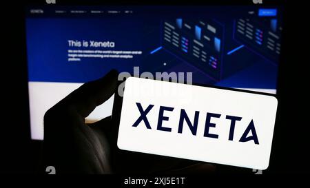 Stuttgart, Allemagne, 02-13-2024 : personne tenant un smartphone avec le logo de la société norvégienne d'analyse d'expédition Xeneta COMME en face du site Web. Concentrez-vous sur Banque D'Images