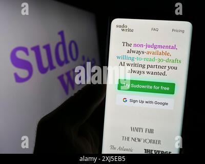 Stuttgart, Allemagne, 02-15-2024 : personne tenant un smartphone avec une page web de la société d'assistant d'écriture d'intelligence artificielle Sudowrite avec logo. Banque D'Images