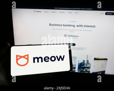 Stuttgart, Allemagne, 02-14-2024 : personne tenant un smartphone avec le logo de la société américaine de fintech Meow technologies devant le site Web. Concentrez-vous sur le téléphone Banque D'Images