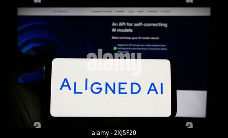 Stuttgart, Allemagne, 02-19-2024 : personne tenant un téléphone portable avec le logo de la société britannique d'intelligence artificielle alignée ai devant les affaires Banque D'Images