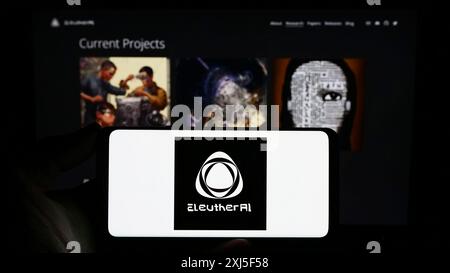 Stuttgart, Allemagne, 02-16-2024 : personne tenant un smartphone avec le logo du groupe de recherche en intelligence artificielle EleutherAI devant le site web. Mise au point Banque D'Images