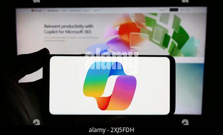 Stuttgart, Allemagne, 02-22-2024 : personne tenant un smartphone avec le logo du chatbot d'intelligence artificielle Microsoft CoPilot devant le site Web. Mise au point Banque D'Images