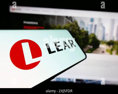 Stuttgart, Allemagne, 02-22-2024 : téléphone portable avec le logo de la société américaine de fournitures automobiles Lear Corporation devant le site. Concentrez-vous sur Banque D'Images