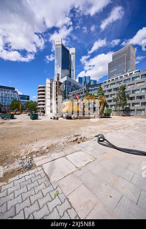 Chantier de construction pour la démolition d'un bâtiment avec pelle hydraulique CAT 374F sous un ciel bleu avec cumulus nuages dans le centre-ville de Banque D'Images